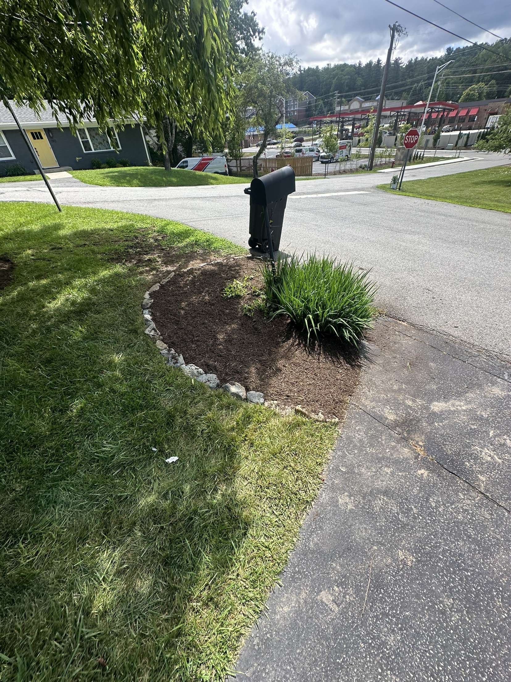 Mulch bed with stone edging around mailbox