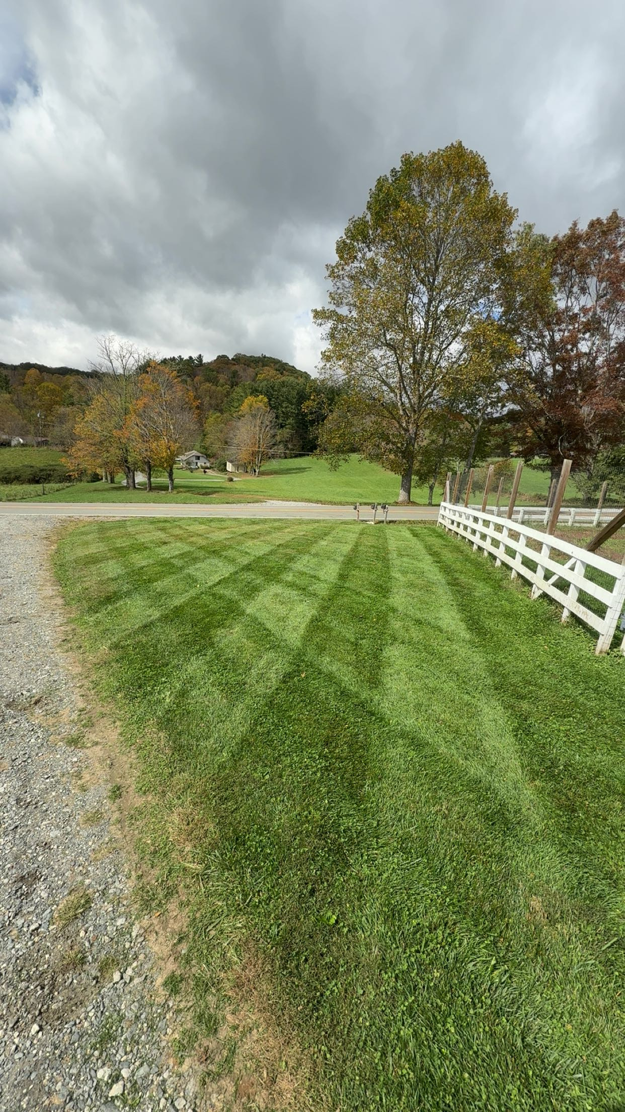Striped lawn with white fence
